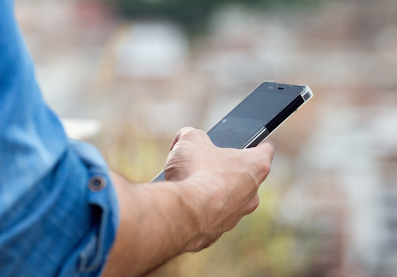 Person am Handy mit Kaffee